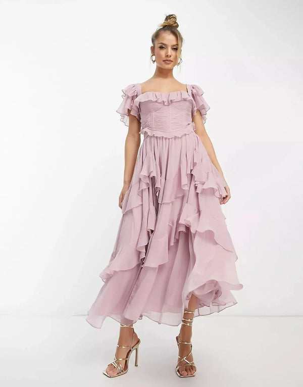 Blush pink ruffle midi dress with off-shoulder sleeves and flowing layered skirt, wedding guest dress