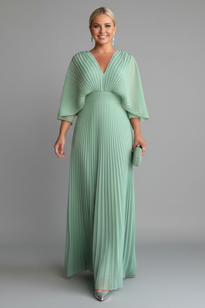 Soft green pleated maxi dress with V neck, sheer cape sleeves, and fitted waist