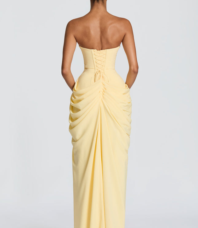 Back view pale yellow strapless corset maxi dress with lace-up detail and ruched draped skirt