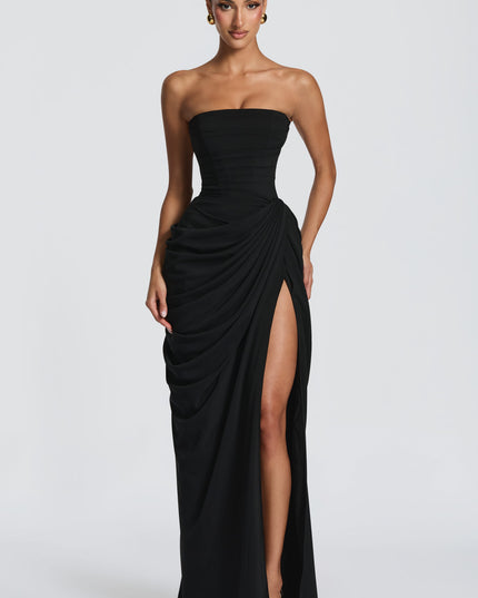 Back view of black strapless corset dress with lace-up detail and draped maxi skirt