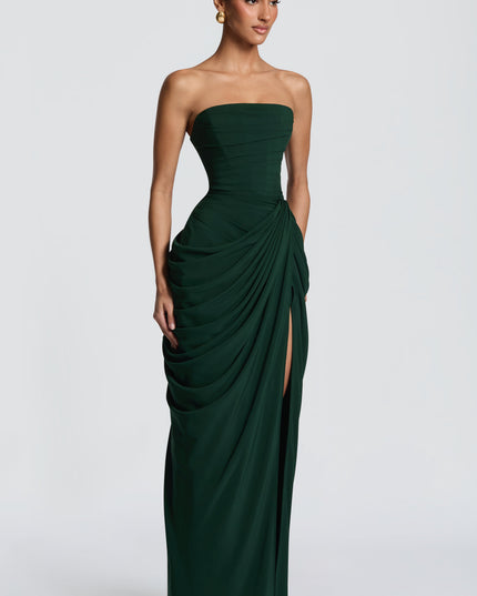 Side view of dark green strapless maxi dress with draped skirt and high leg slit
