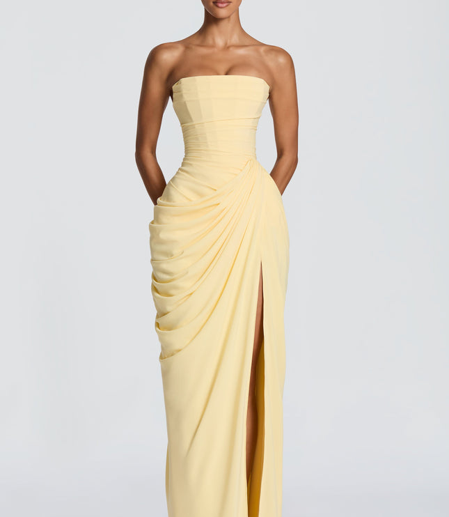 Pale yellow strapless corset maxi dress with gathered waist draping and thigh-high slit, straight on