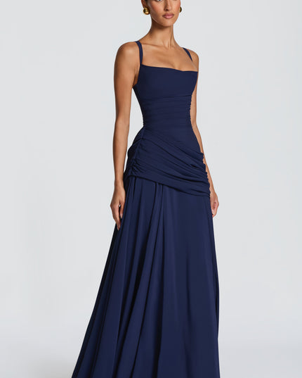 Three-quarter view navy square neck wedding guest maxi dress with ruched waist and flowy skirt
