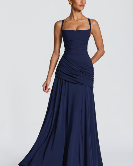 Three-quarter view navy blue square neck womens dress with ruched hip and flowing maxi skirt