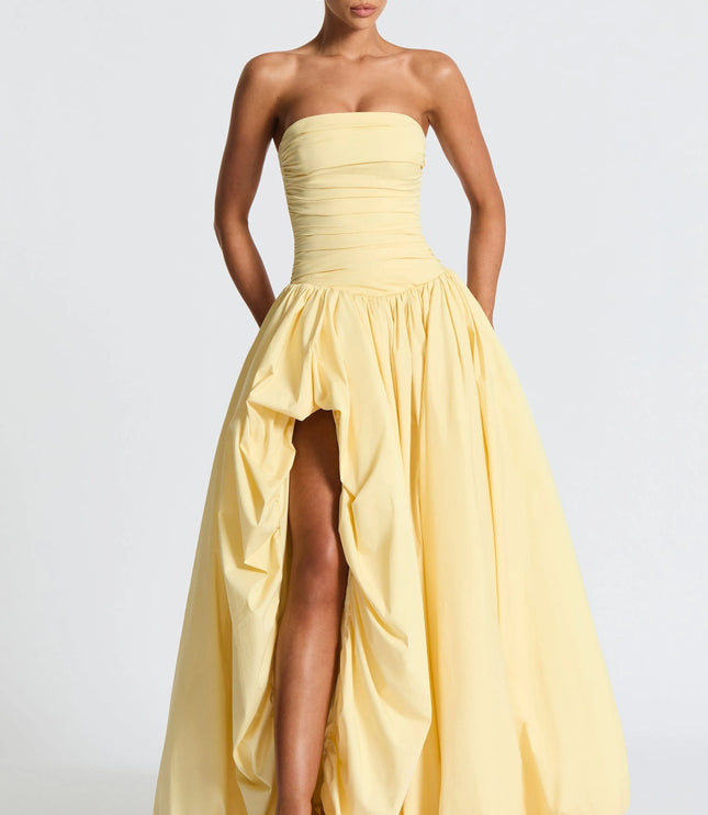 Full length pale yellow strapless high low maxi dress with voluminous skirt and front slit