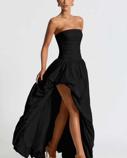 Angled view of black strapless high low womens dress showing gathered skirt and high front hem