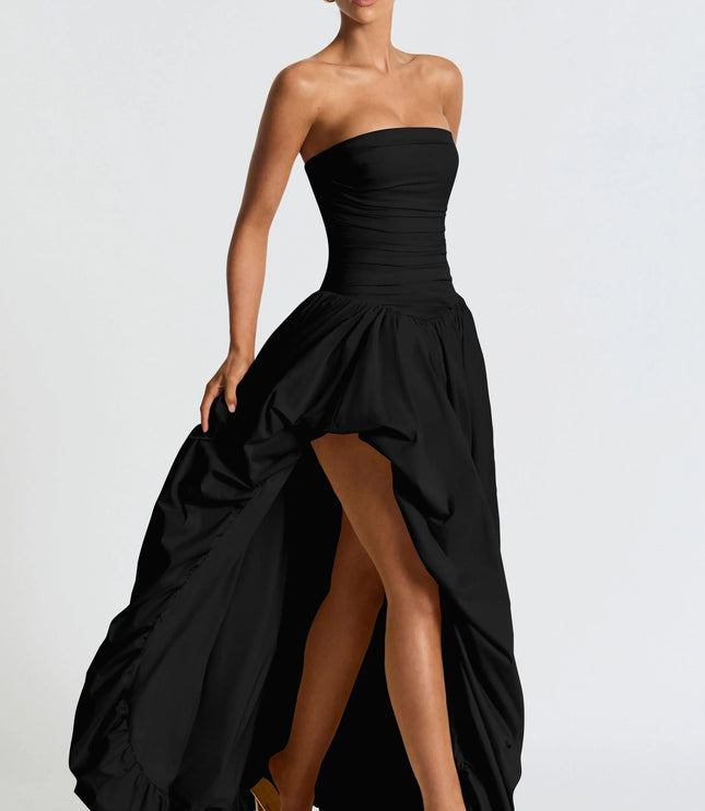 Angled view of black strapless high low womens dress showing gathered skirt and high front hem