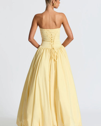Back view of pale yellow strapless womens dress with lace-up corset back and full maxi skirt