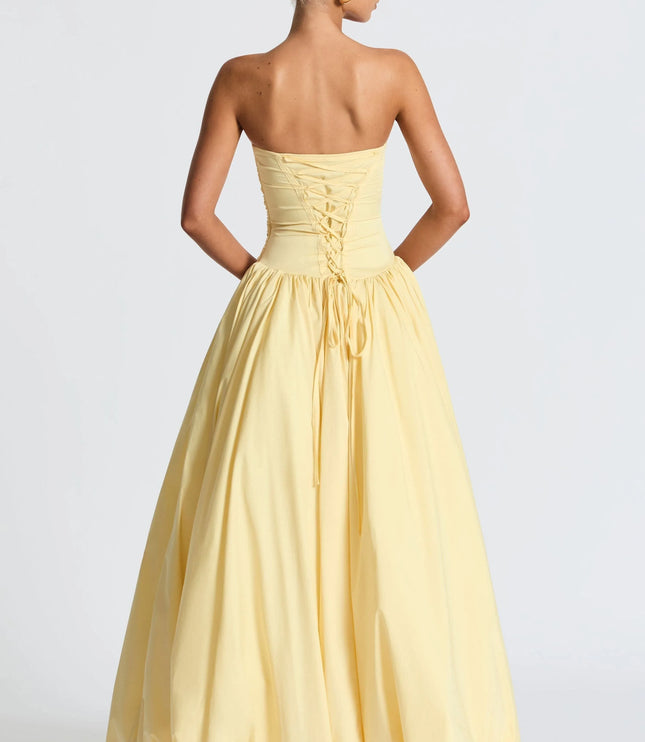 Back view of pale yellow strapless womens dress with lace-up corset back and full maxi skirt