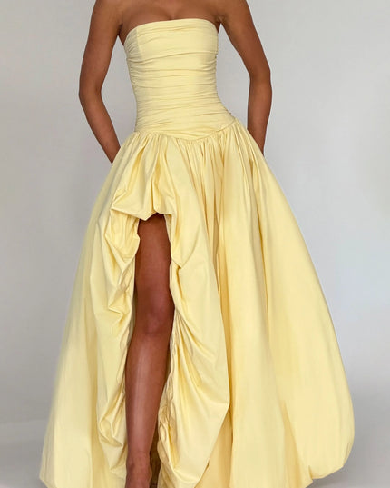 Cropped view of pale yellow strapless cocktail dress showing ruched bodice and high low skirt