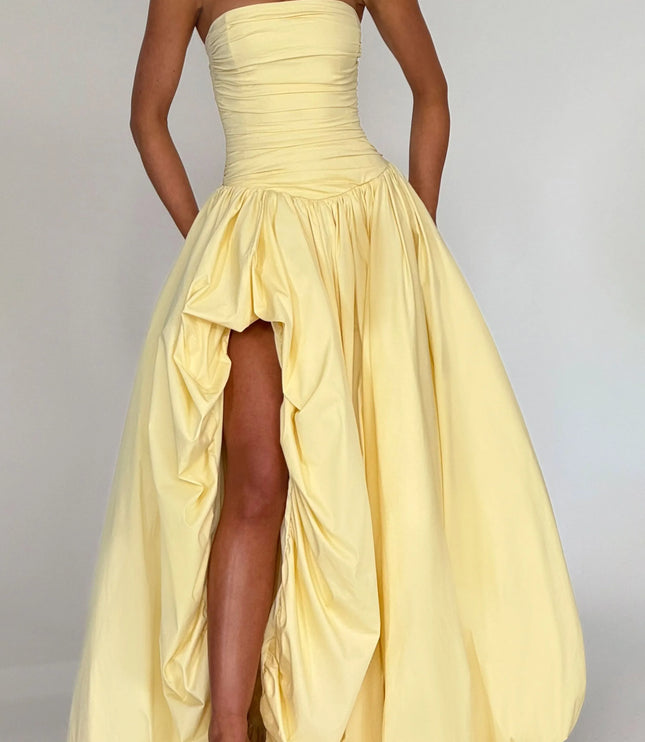 Cropped view of pale yellow strapless cocktail dress showing ruched bodice and high low skirt