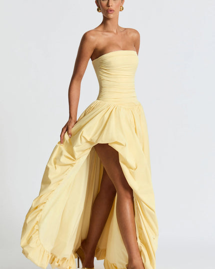 Three-quarter view pale yellow strapless high low maxi cocktail dress with dramatic draped skirt