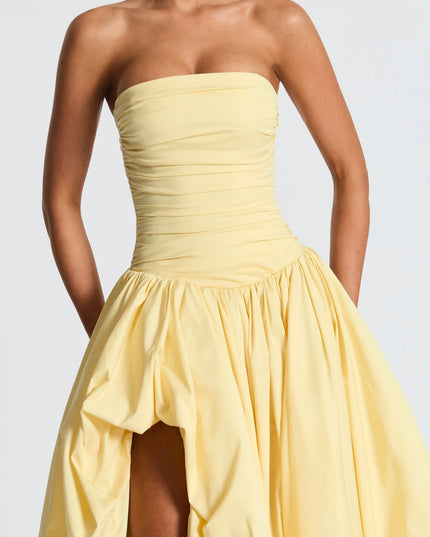 Close-up of pale yellow strapless high low maxi cocktail dress bodice with soft ruching detail