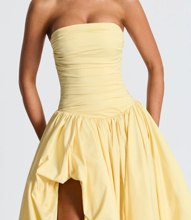 Close-up of pale yellow strapless high low maxi cocktail dress bodice with soft ruching detail