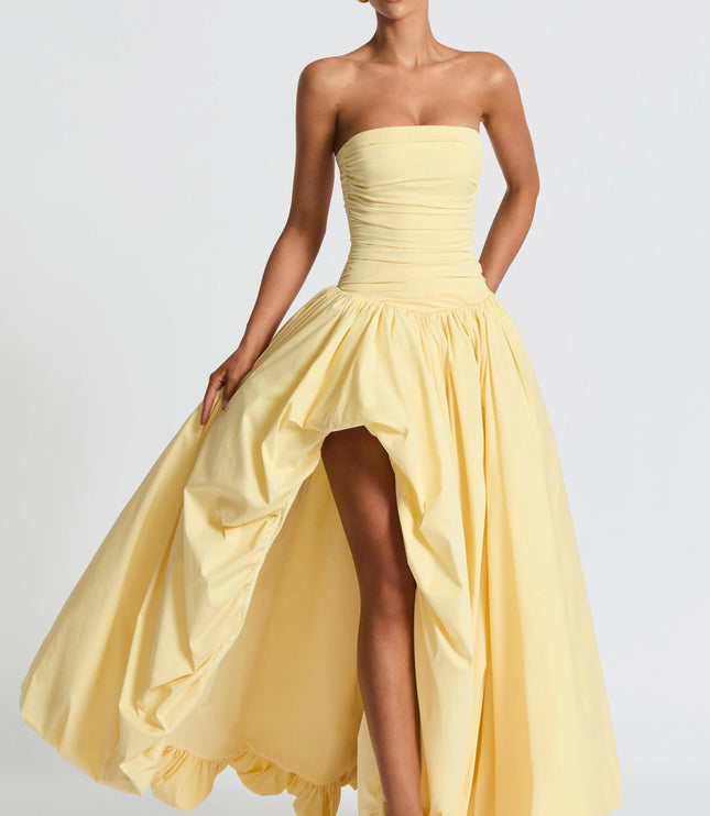 Pale yellow strapless high low maxi cocktail dress with ruched bodice and voluminous skirt