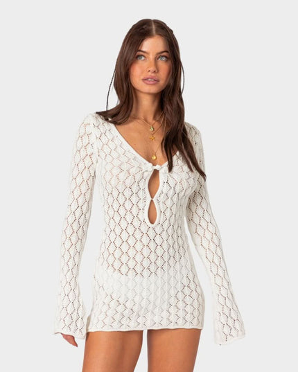 White crochet mini dress with tie front detail, long sleeves, and sheer lace texture