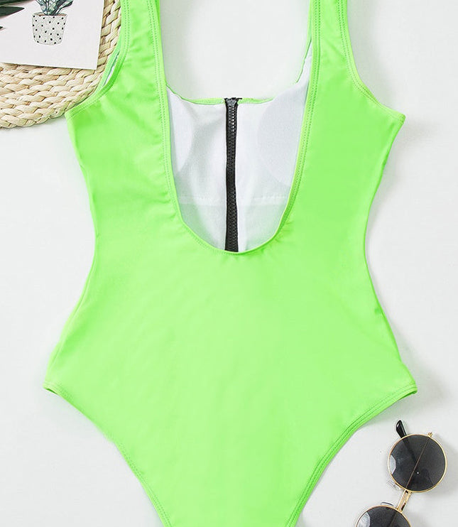 Neon green one piece bathing suit laid flat with black zipper and wide shoulder straps