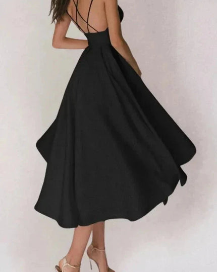 Back view of black open back midi dress with crisscross straps and flowy skirt