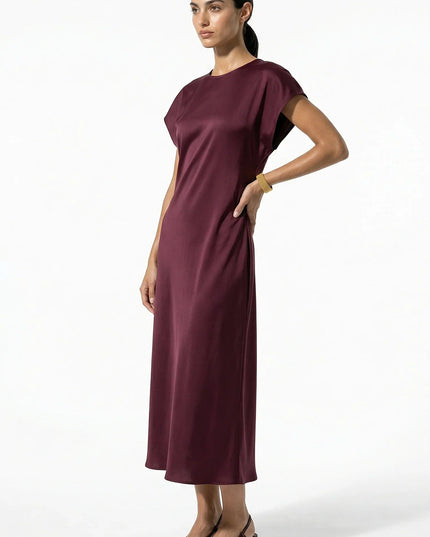 Side view of burgundy satin midi dress with midi length and soft drape