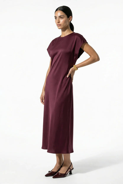 Side view of burgundy satin midi dress with midi length and soft drape