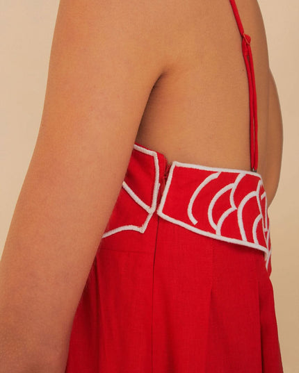Close-up of red fish print maxi dress showing open back, thin strap, and scalloped trim
