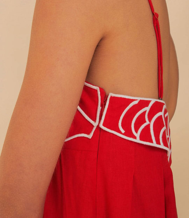 Close-up of red fish print maxi dress showing open back, thin strap, and scalloped trim