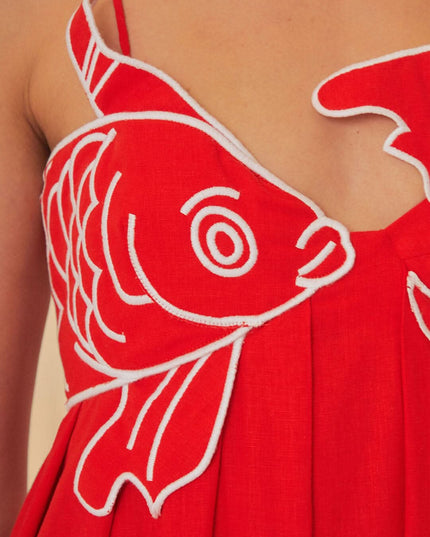 Close-up of red fish print maxi dress bodice with bold fish graphic and V neckline