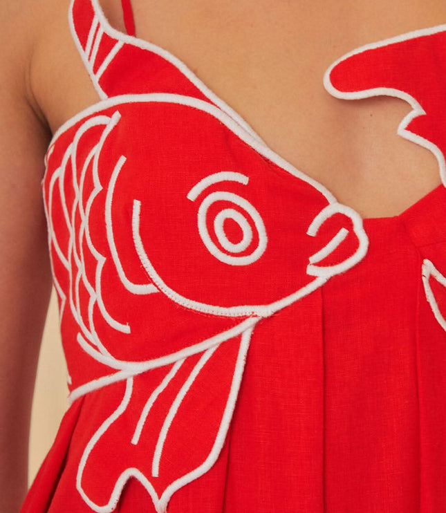 Close-up of red fish print maxi dress bodice with bold fish graphic and V neckline