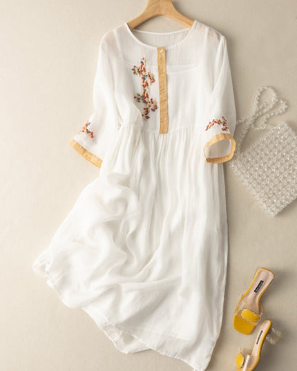 White women's summer embroidered midi dress with tan trim and sheer flowing skirt