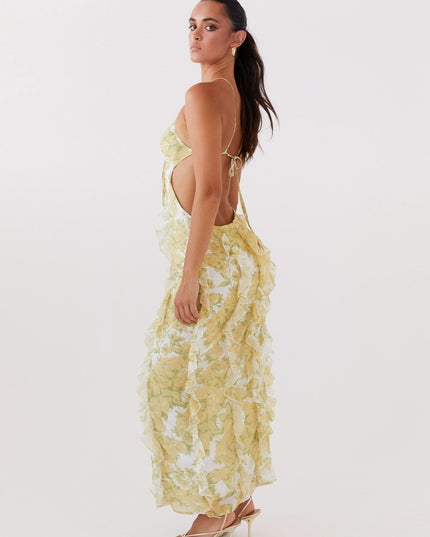Side view of floral maxi dress with open back, thin straps, and flowing ruffle details
