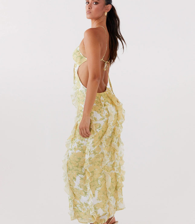 Side view of floral maxi dress with open back, thin straps, and flowing ruffle details