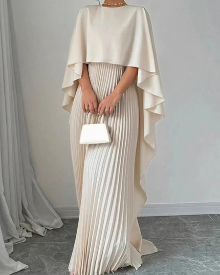 Front view of cream formal maxi dress with cape overlay, pleated skirt, and clutch