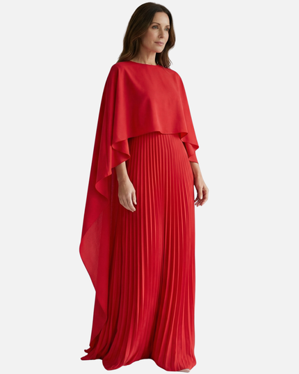 Side view of red formal maxi dress with flowing cape overlay and pleated skirt