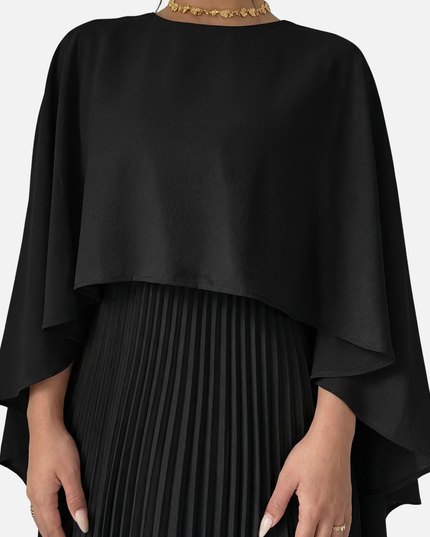 Close-up of black cape overlay maxi dress with pleated skirt and draped formal top