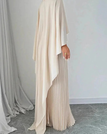 Back view of cream cape overlay maxi dress with flowing drape and pleated skirt