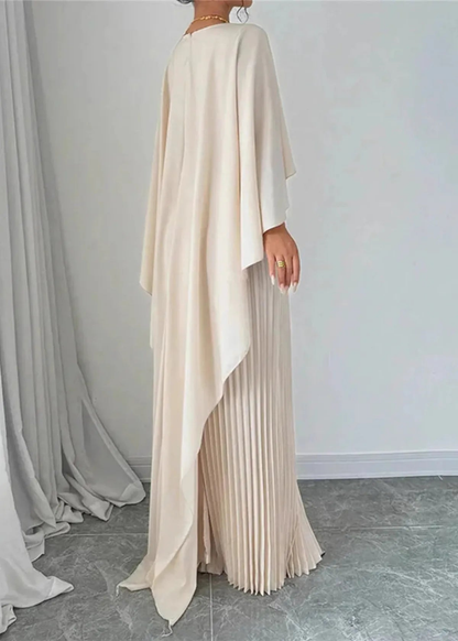 Back view of cream cape overlay maxi dress with flowing drape and pleated skirt