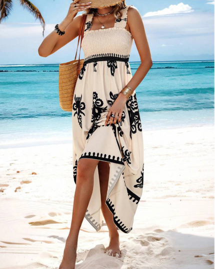 Cream floral maxi dress with black print worn at the beach, sleeveless summer dress with high-low hem