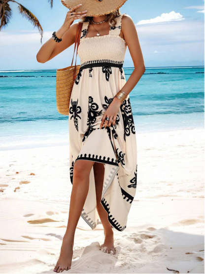 Cream floral maxi dress with black print worn at the beach, sleeveless summer dress with high-low hem