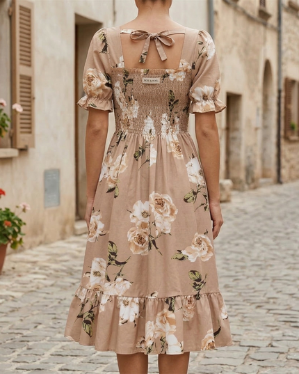 Back view of beige floral midi dress with square back, tie detail, and ruffled hem