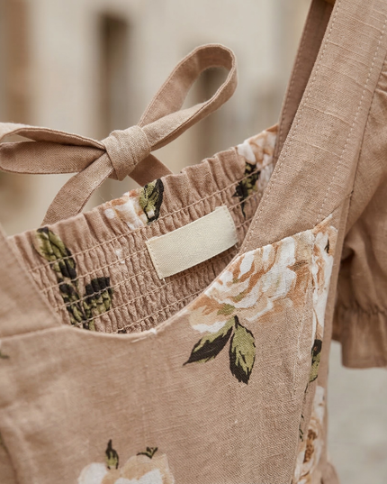 Close-up of floral square neck midi dress showing smocked bodice, back tie, and puff sleeve