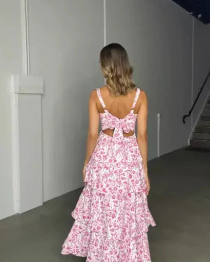 Back view of pink floral midi dress with open back bow detail and tiered skirt