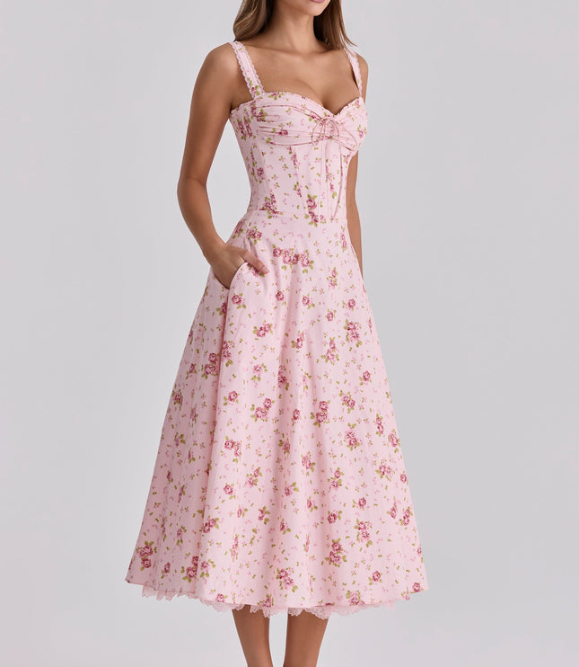 Three-quarter front view of pink floral wedding guest dress with fitted waist and midi length