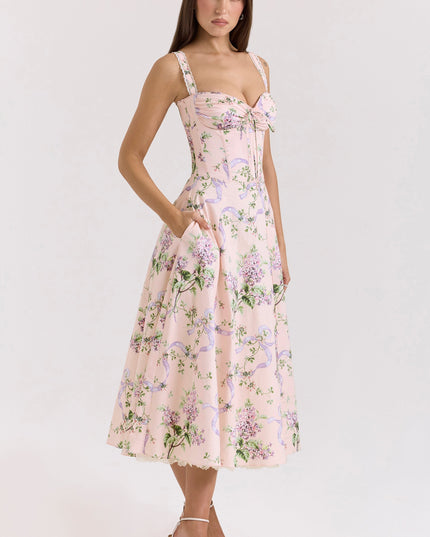 Side front view of pink floral wedding guest midi dress with fitted corset waist