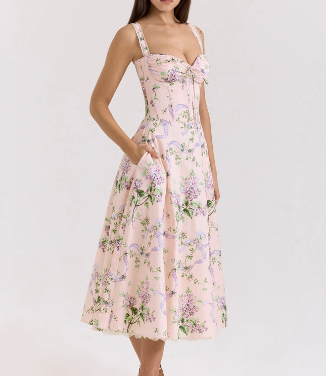Side front view of pink floral wedding guest midi dress with fitted corset waist