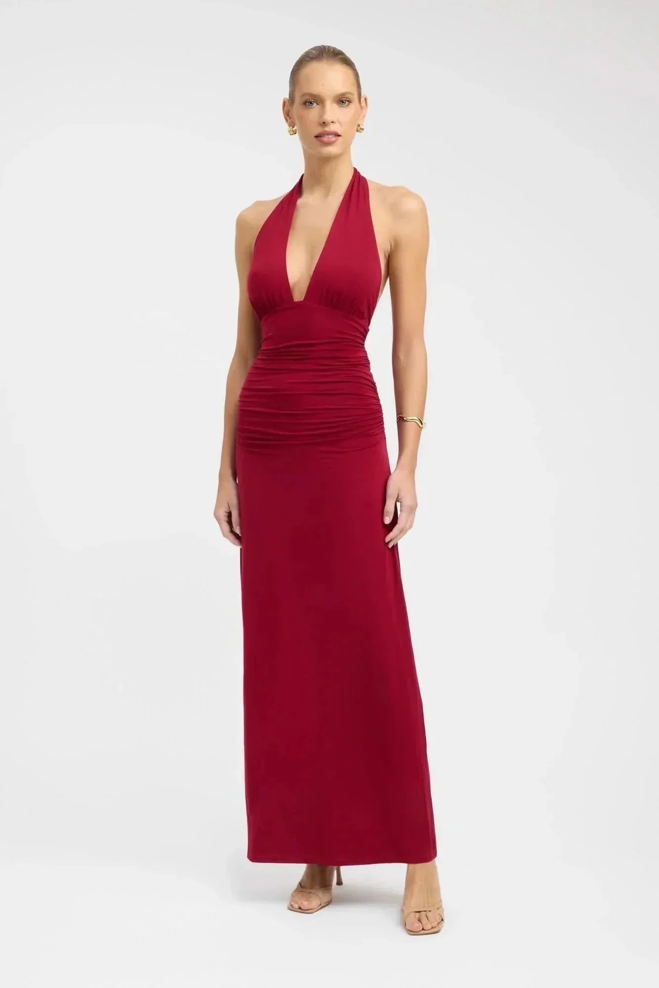 Front view of burgundy formal maxi halter dress with deep V neckline and ruched waist