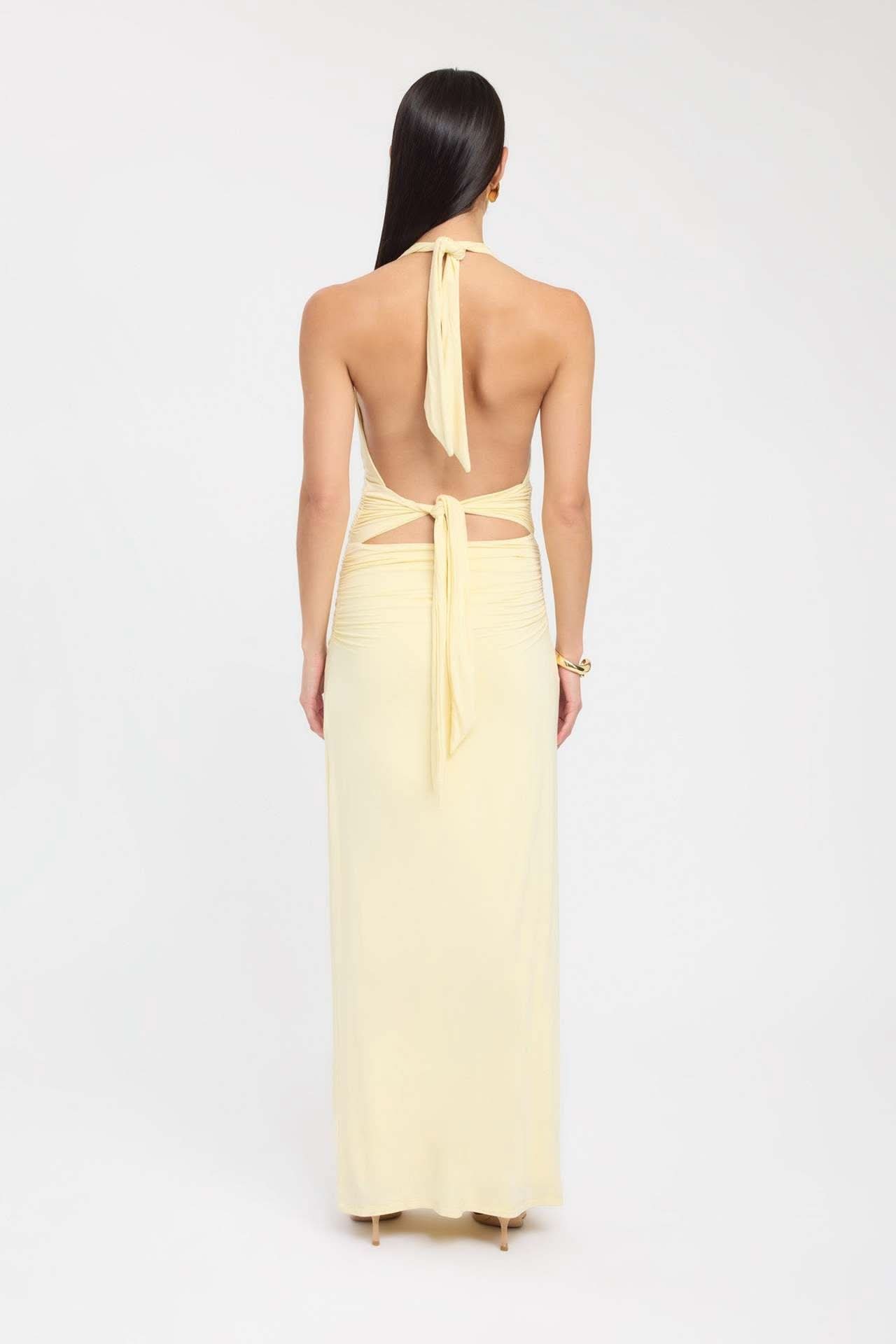 Back view of pale yellow formal maxi halter dress with open back and tie waist