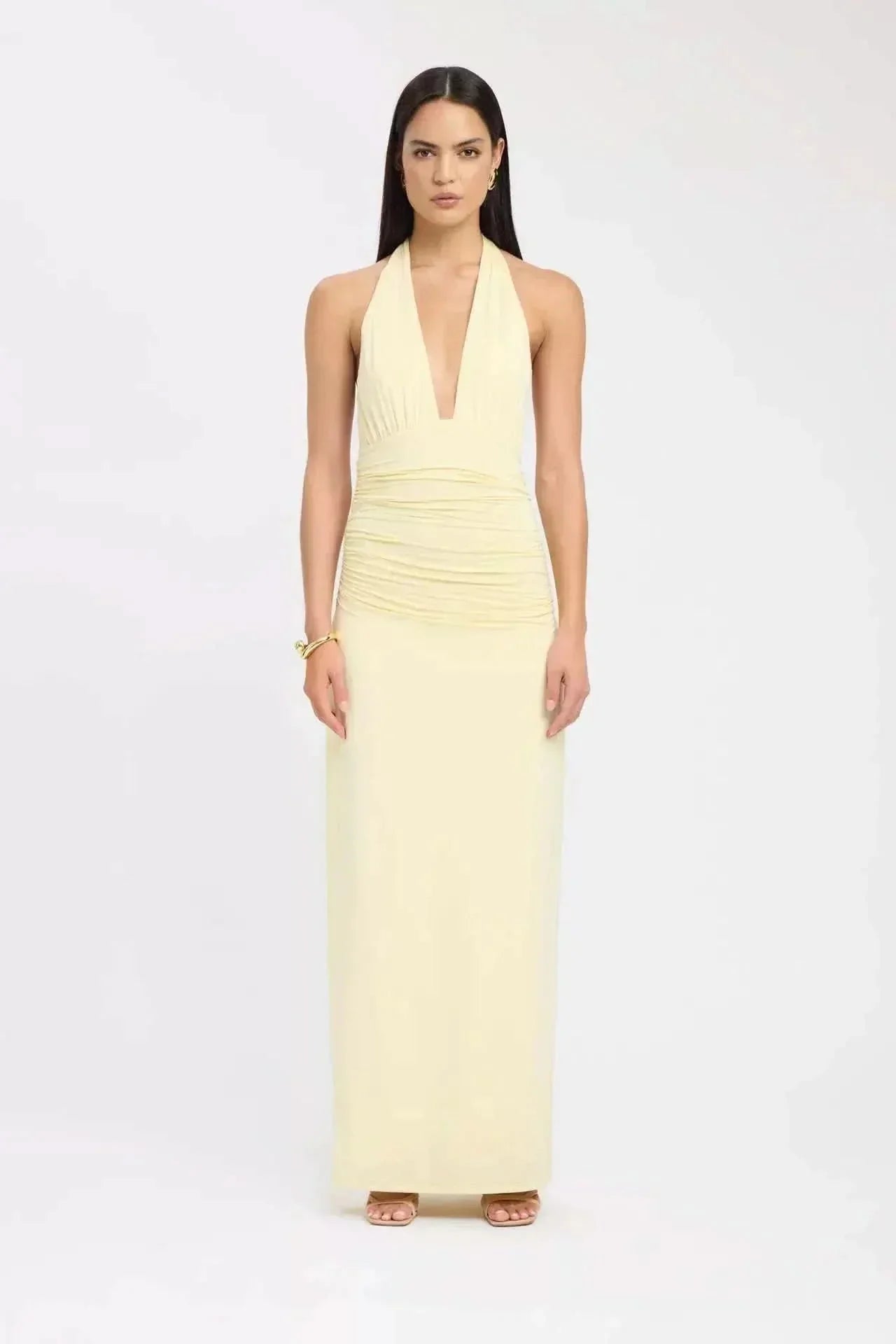 Front view of pale yellow formal maxi halter dress with plunging neckline and fitted skirt