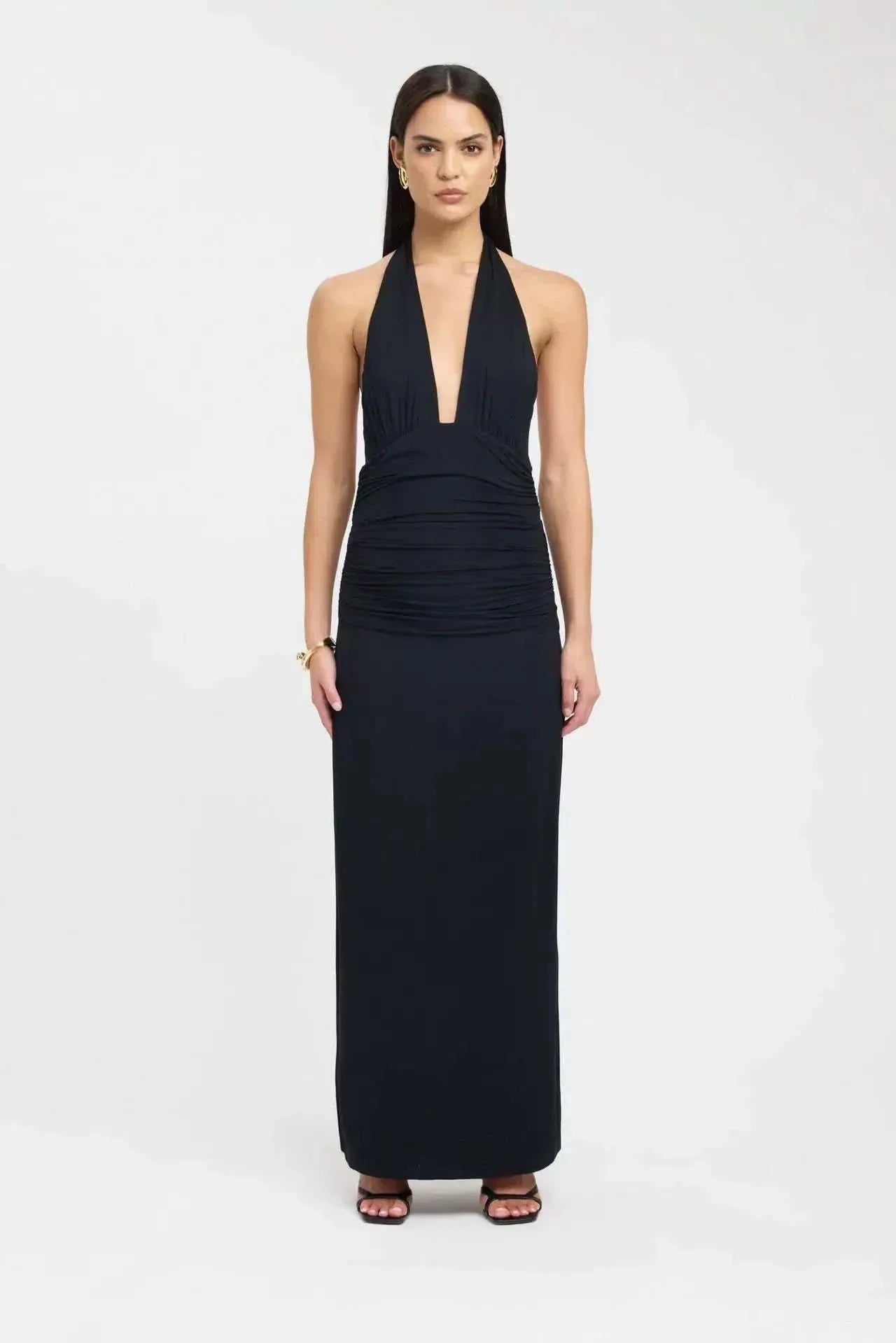 Back view of a black maxi dress with open back, tie waist detail, and long skirt