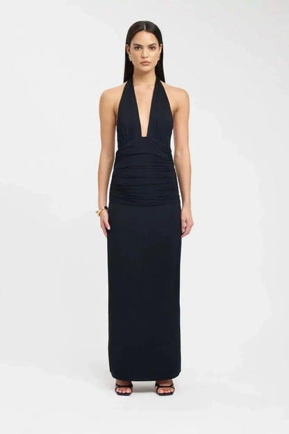 Back view of a black maxi dress with open back, tie waist detail, and long skirt