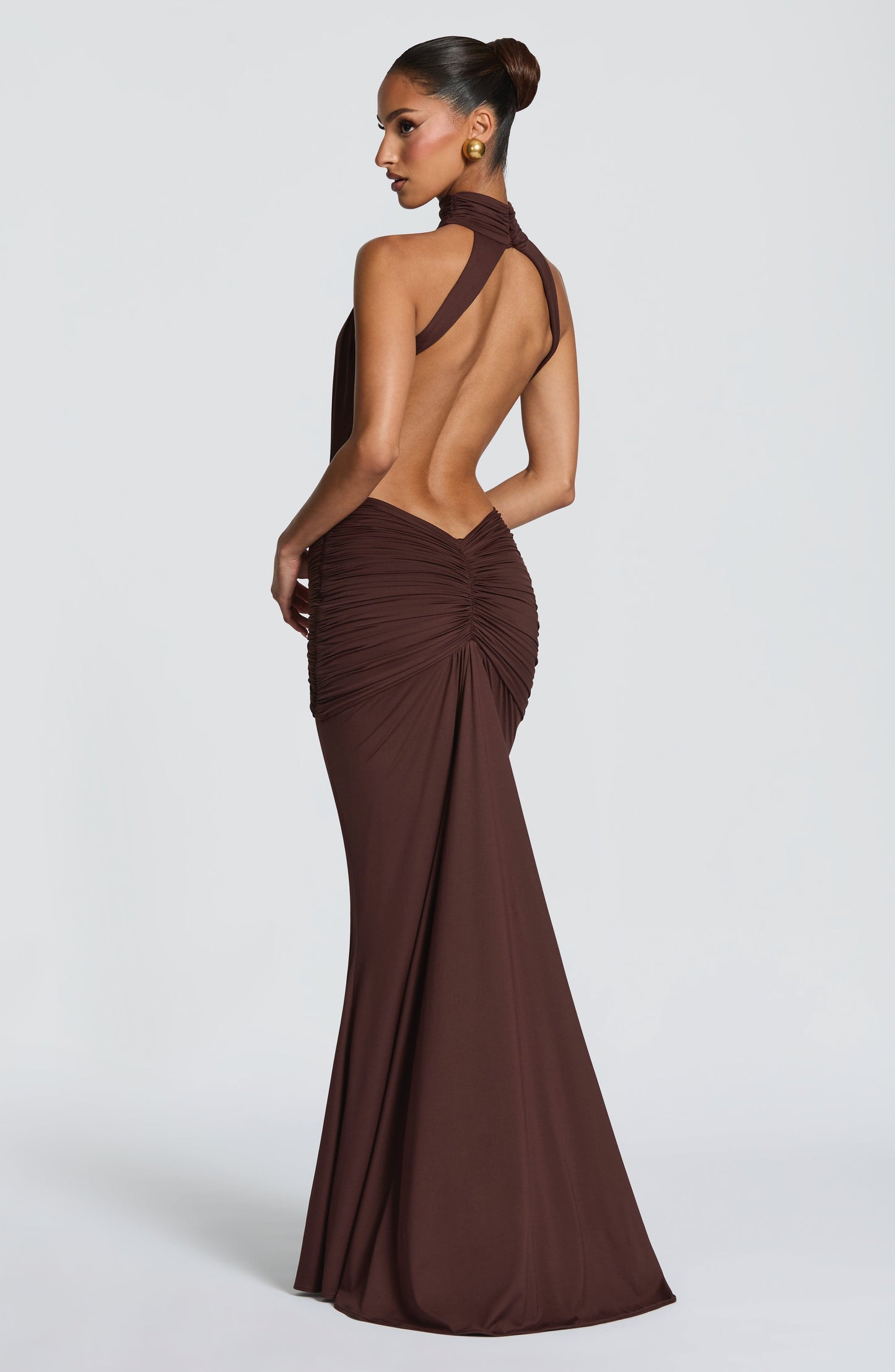 Side back view of brown ruched maxi dress showing halter neckline and open back
